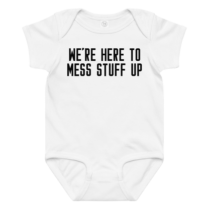 "We're Here To Mess Stuff Up" printed on a white baby jersey bodysuit laying on a flat surface amongst other clothes