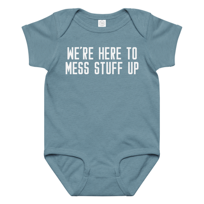 "We're Here To Mess Stuff Up" printed on a vintage indigo baby jersey bodysuit laying on a flat surface amongst other clothes