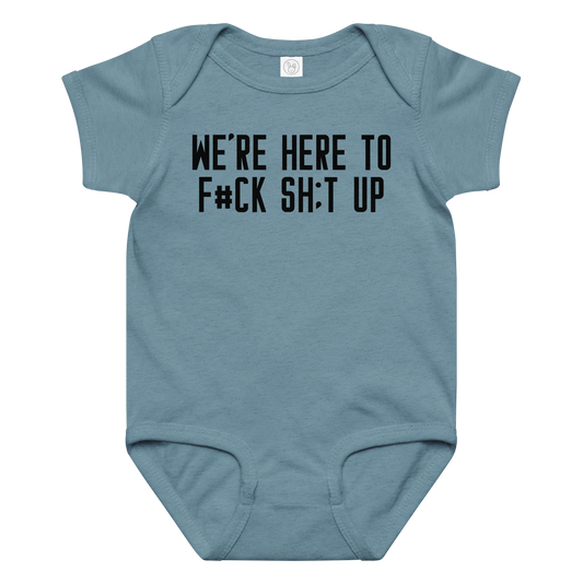 "We're Here To F#Ck Sh:t Up" printed on a vintage indigo baby jersey bodysuit laying on a flat surface amongst other clothes