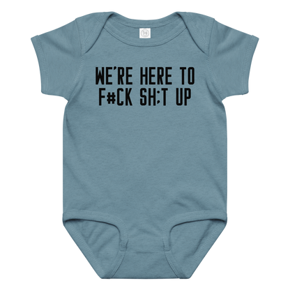 "We're Here To F#Ck Sh:t Up" printed on a vintage indigo baby jersey bodysuit laying on a flat surface amongst other clothes