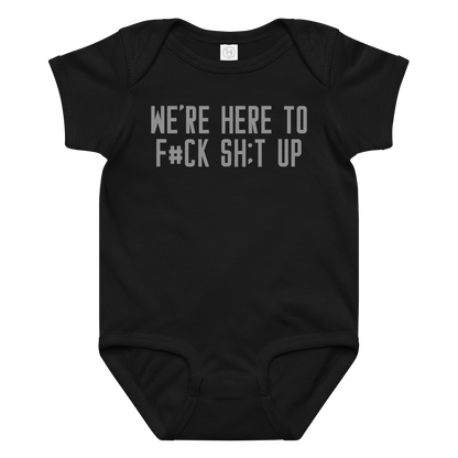 "We're Here To F#Ck Sh:t Up" printed on a black baby jersey bodysuit laying on a flat surface amongst other clothes