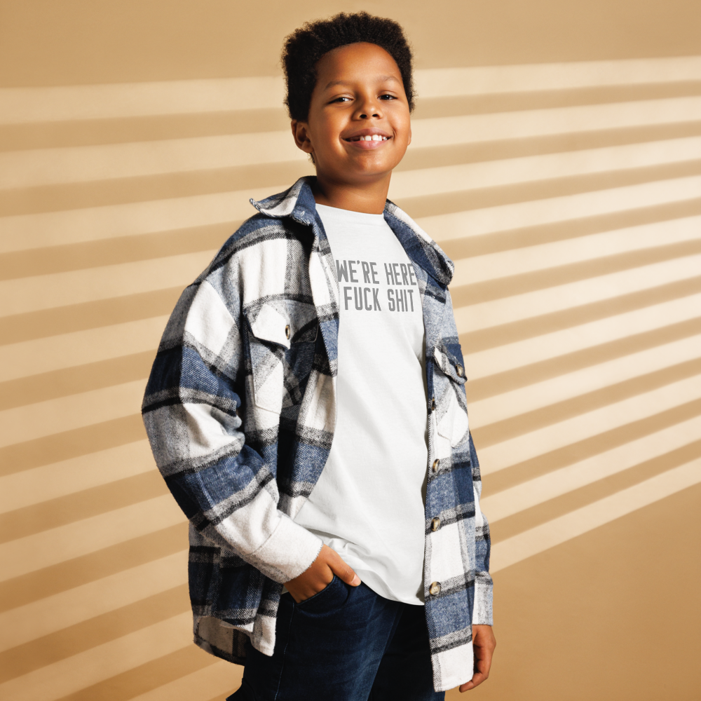 "We're Here To Fuck Shit Up" printed on a white youth classic tee worn by a male also wearing a jacket