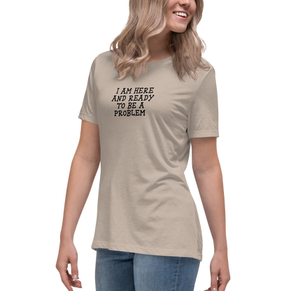 "I am here and ready to be a problem" printed on a heather stone women's relaxed t-shirt worn by a female