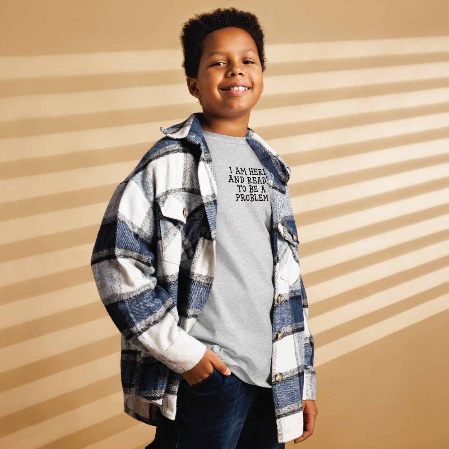 "I am here and ready to be a problem" printed on a sport grey youth classic tee worn by a male also wearing a jacket