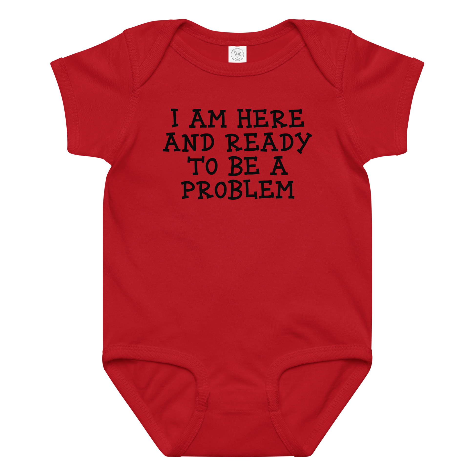 "I am here and ready to be a problem" printed on a red baby jersey bodysuit laying on a flat surface amongst other clothes