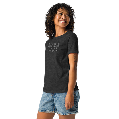 "I am here and ready to be a problem" printed on a dark grey heather women's relaxed t-shirt worn by a female