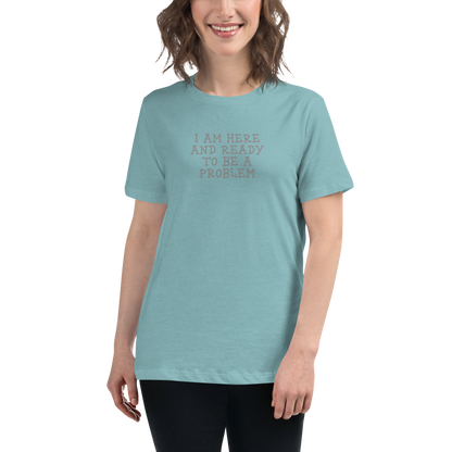 "I am here and ready to be a problem" printed on a heather blue lagoon women's relaxed t-shirt worn by a female