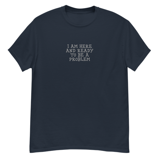 "I am here and ready to be a problem" printed on a navy unisex classic tee laying on a flat surface