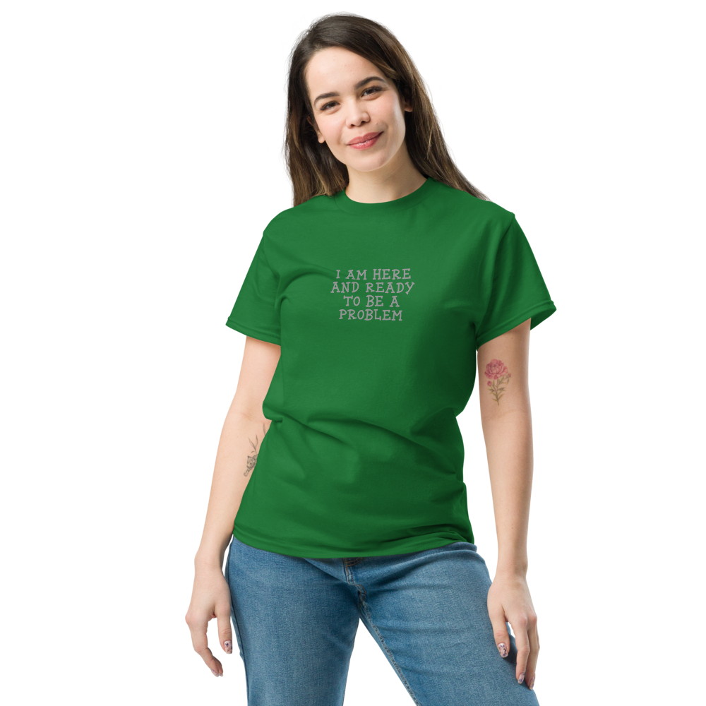"I am here and ready to be a problem" printed on a turf green unisex classic tee worn by a female