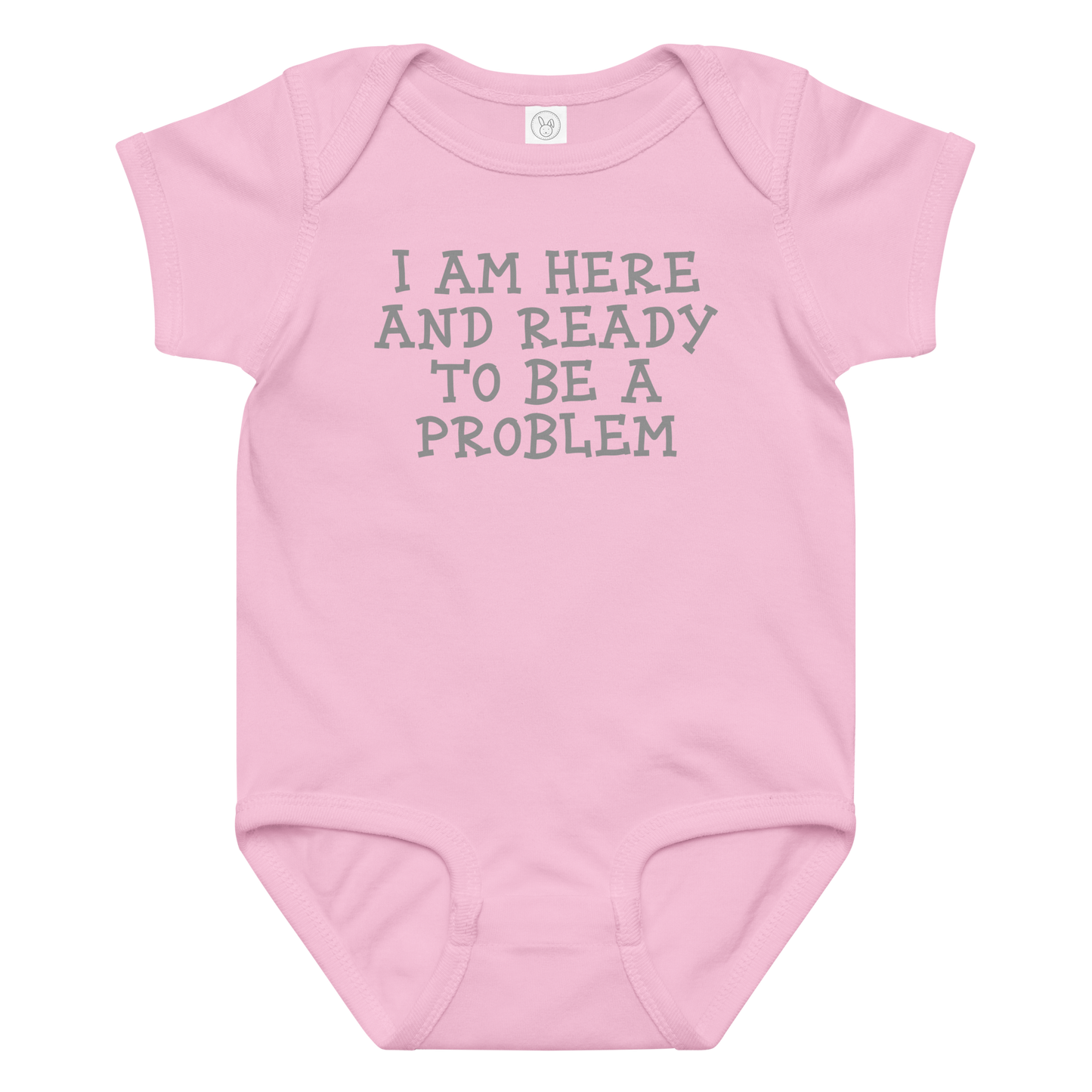 "I am here and ready to be a problem" printed on a pink baby jersey bodysuit laying on a flat surface amongst other clothes