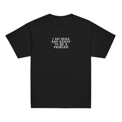 "I am here and ready to be a problem" printed on a black youth classic tee laying on a flat surface