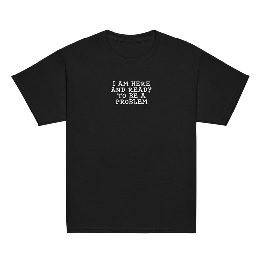"I am here and ready to be a problem" printed on a black youth classic tee laying on a flat surface