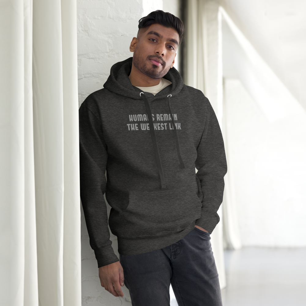 "Humans remain the weakest link" printed on a charcoal heather unisex hoodie worn by a male