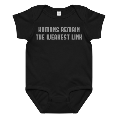 "Humans remain the weakest link" printed on a black baby jersey bodysuit laying on a flat surface amongst other clothes
