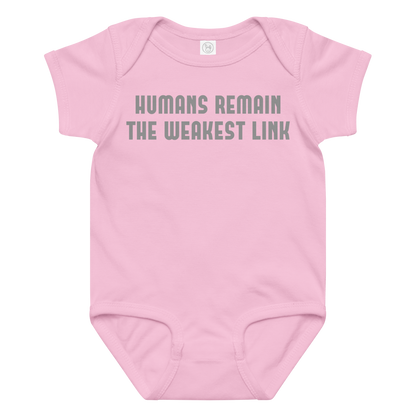 "Humans remain the weakest link" printed on a pink baby jersey bodysuit laying on a flat surface amongst other clothes
