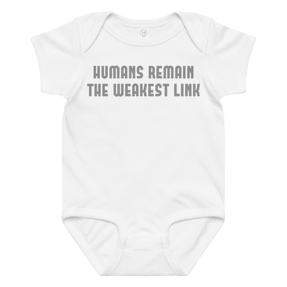 "Humans remain the weakest link" printed on a white baby jersey bodysuit laying on a flat surface amongst other clothes