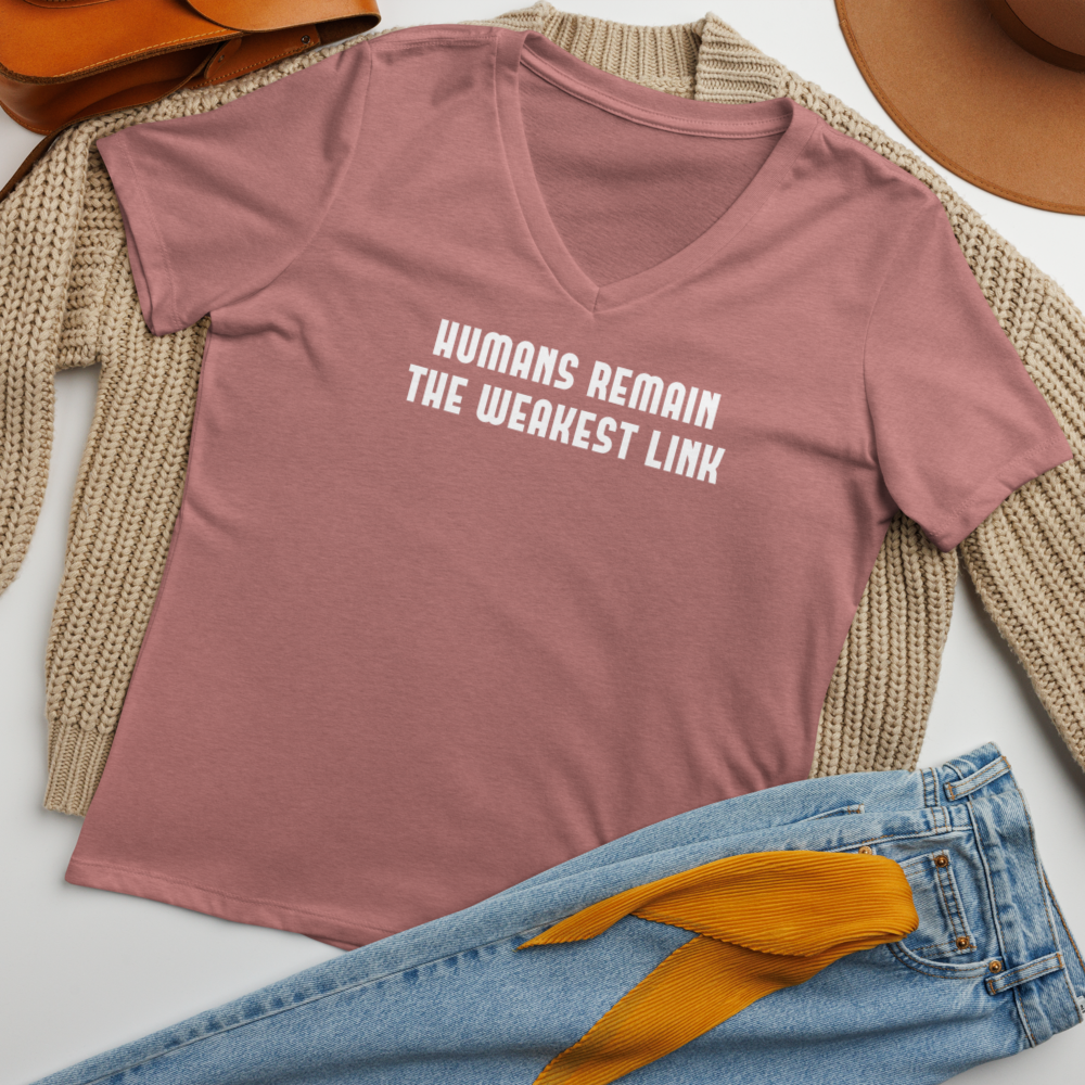 "Humans remain the weakest link" printed on a heather mauve women's relaxed v-neck t-shirt laying on a flat surface amongst other clothes