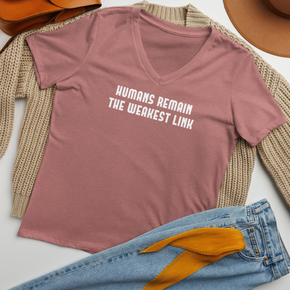 "Humans remain the weakest link" printed on a heather mauve women's relaxed v-neck t-shirt laying on a flat surface amongst other clothes