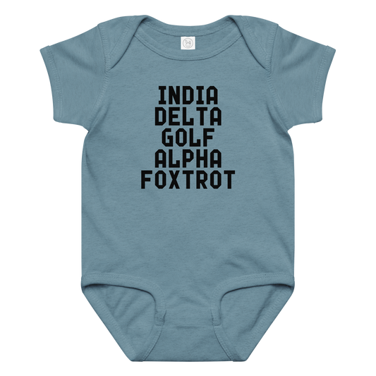 "India Delta Golf Alpha Foxtrot" printed on a vintage indigo baby jersey bodysuit laying on a flat surface amongst other clothes