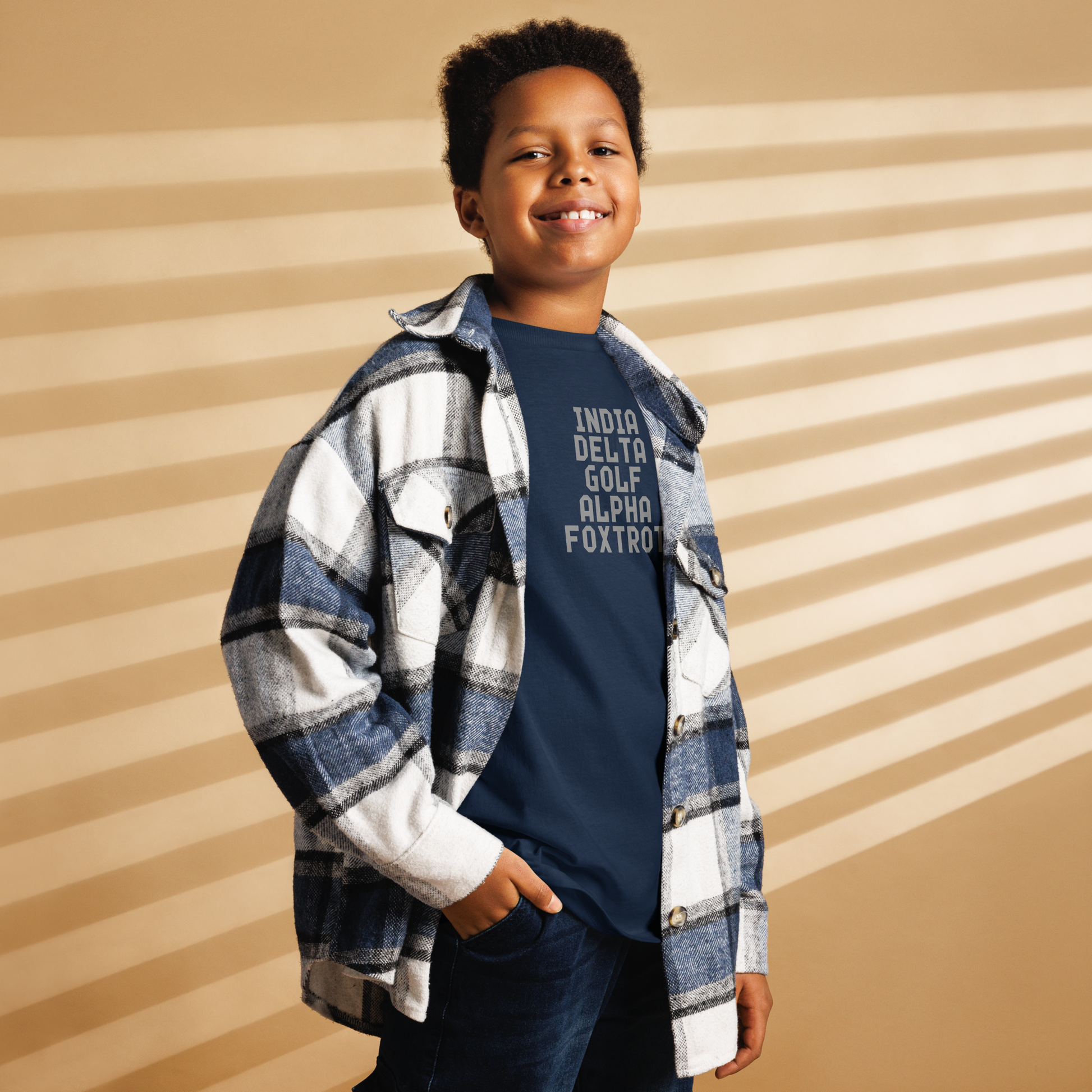 "India Delta Golf Alpha Foxtrot" printed on a navy youth classic tee worn by a male also wearing a jacket