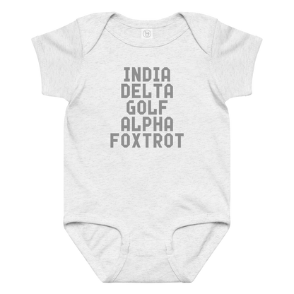 "India Delta Golf Alpha Foxtrot" printed on a ash baby jersey bodysuit laying on a flat surface amongst other clothes