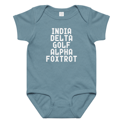 "India Delta Golf Alpha Foxtrot" printed on a vintage indigo baby jersey bodysuit laying on a flat surface amongst other clothes
