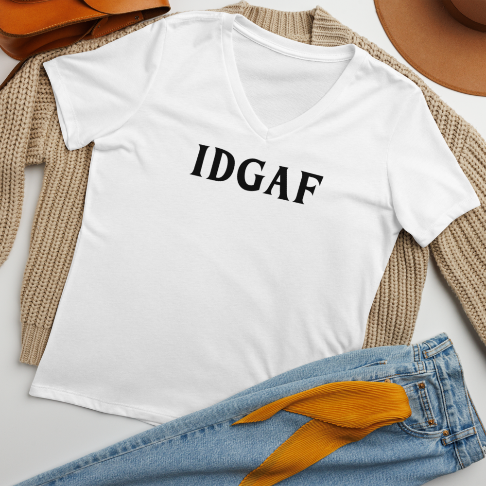"IDGAF" printed on a solid white blend women's relaxed v-neck t-shirt laying on a flat surface amongst other clothes
