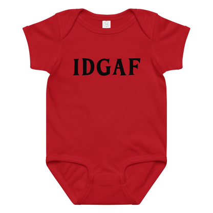 "IDGAF" printed on a red baby jersey bodysuit laying on a flat surface amongst other clothes