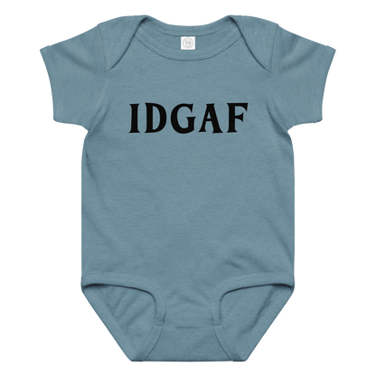 "IDGAF" printed on a vintage indigo baby jersey bodysuit laying on a flat surface amongst other clothes