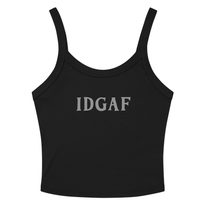 "IDGAF" printed on a solid black blend women's micro-rib tanktop laying on a flat surface amongst sunglasses and shorts