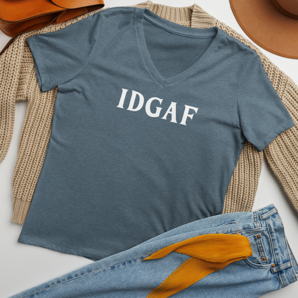 "IDGAF" printed on a heather slate women's relaxed v-neck t-shirt laying on a flat surface amongst other clothes