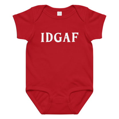 "IDGAF" printed on a red baby jersey bodysuit laying on a flat surface amongst other clothes