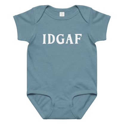 "IDGAF" printed on a vintage indigo baby jersey bodysuit laying on a flat surface amongst other clothes