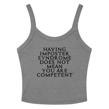 "Having Imposter Syndrome does not mean you are competent" printed on a athletic heather women's micro-rib tanktop laying on a flat surface amongst sunglasses and shorts