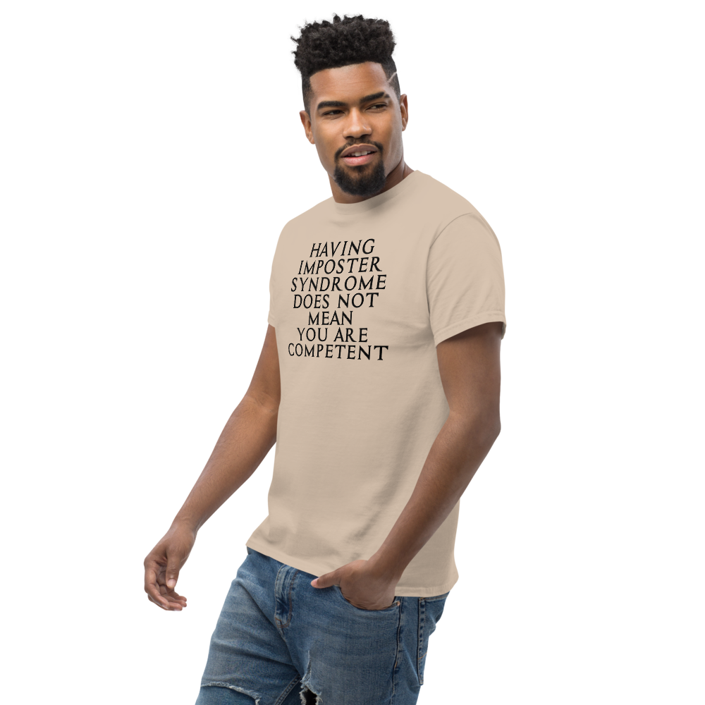 "Having Imposter Syndrome does not mean you are competent" printed on a sand unisex classic tee worn by a male