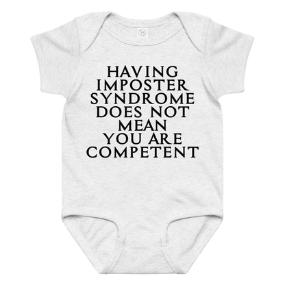"Having Imposter Syndrome does not mean you are competent" printed on a ash baby jersey bodysuit laying on a flat surface amongst other clothes