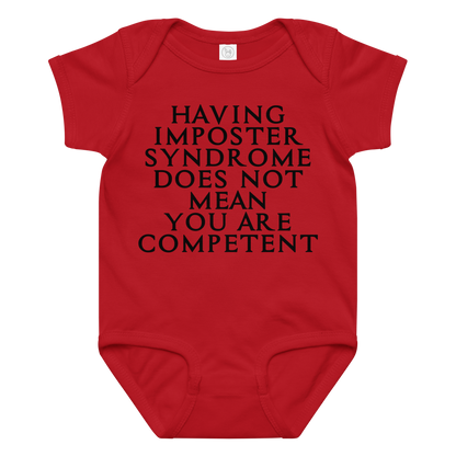 "Having Imposter Syndrome does not mean you are competent" printed on a red baby jersey bodysuit laying on a flat surface amongst other clothes