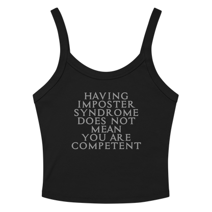 "Having Imposter Syndrome does not mean you are competent" printed on a solid black blend women's micro-rib tanktop laying on a flat surface amongst sunglasses and shorts
