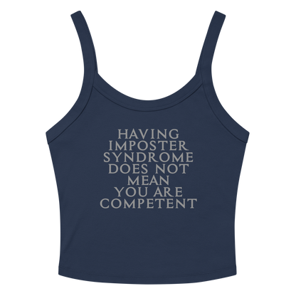 "Having Imposter Syndrome does not mean you are competent" printed on a solid navy blend women's micro-rib tanktop laying on a flat surface amongst sunglasses and shorts