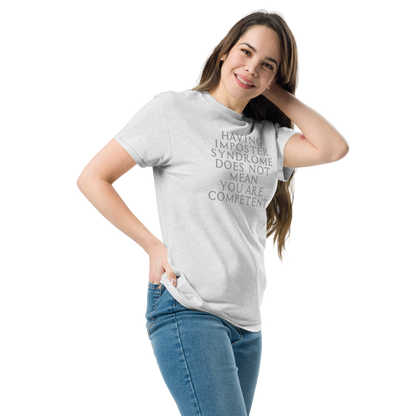 "Having Imposter Syndrome does not mean you are competent" printed on a ash unisex classic tee worn by a female