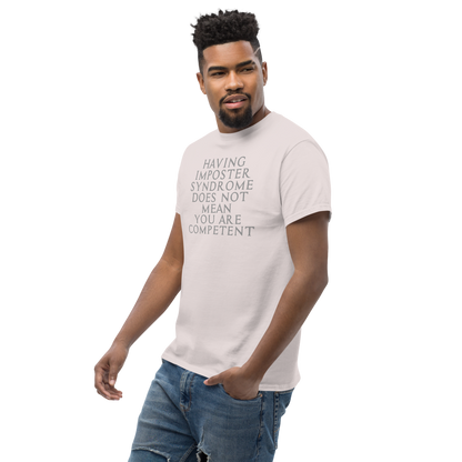 "Having Imposter Syndrome does not mean you are competent" printed on a ice grey unisex classic tee worn by a male