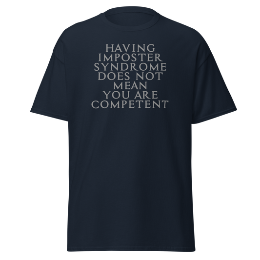 "Having Imposter Syndrome does not mean you are competent" printed on a navy unisex classic tee laying on a flat surface