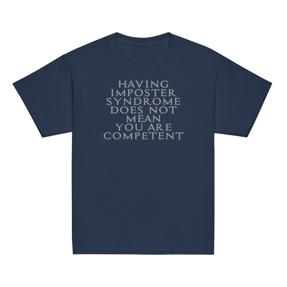 "Having Imposter Syndrome does not mean you are competent" printed on a navy youth classic tee laying on a flat surface