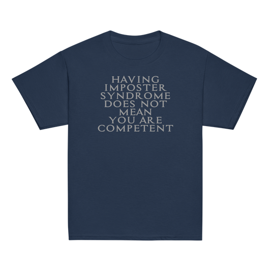 "Having Imposter Syndrome does not mean you are competent" printed on a navy youth classic tee laying on a flat surface