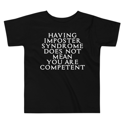 "Having Imposter Syndrome does not mean you are competent" printed on a black toddler short sleeve tee laying on a flat surface