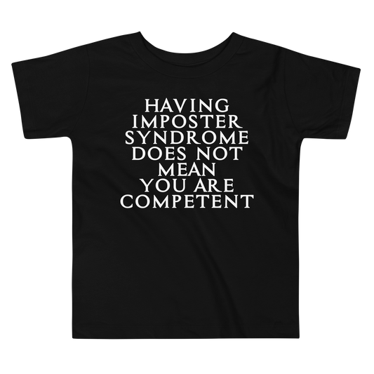 "Having Imposter Syndrome does not mean you are competent" printed on a black toddler short sleeve tee laying on a flat surface