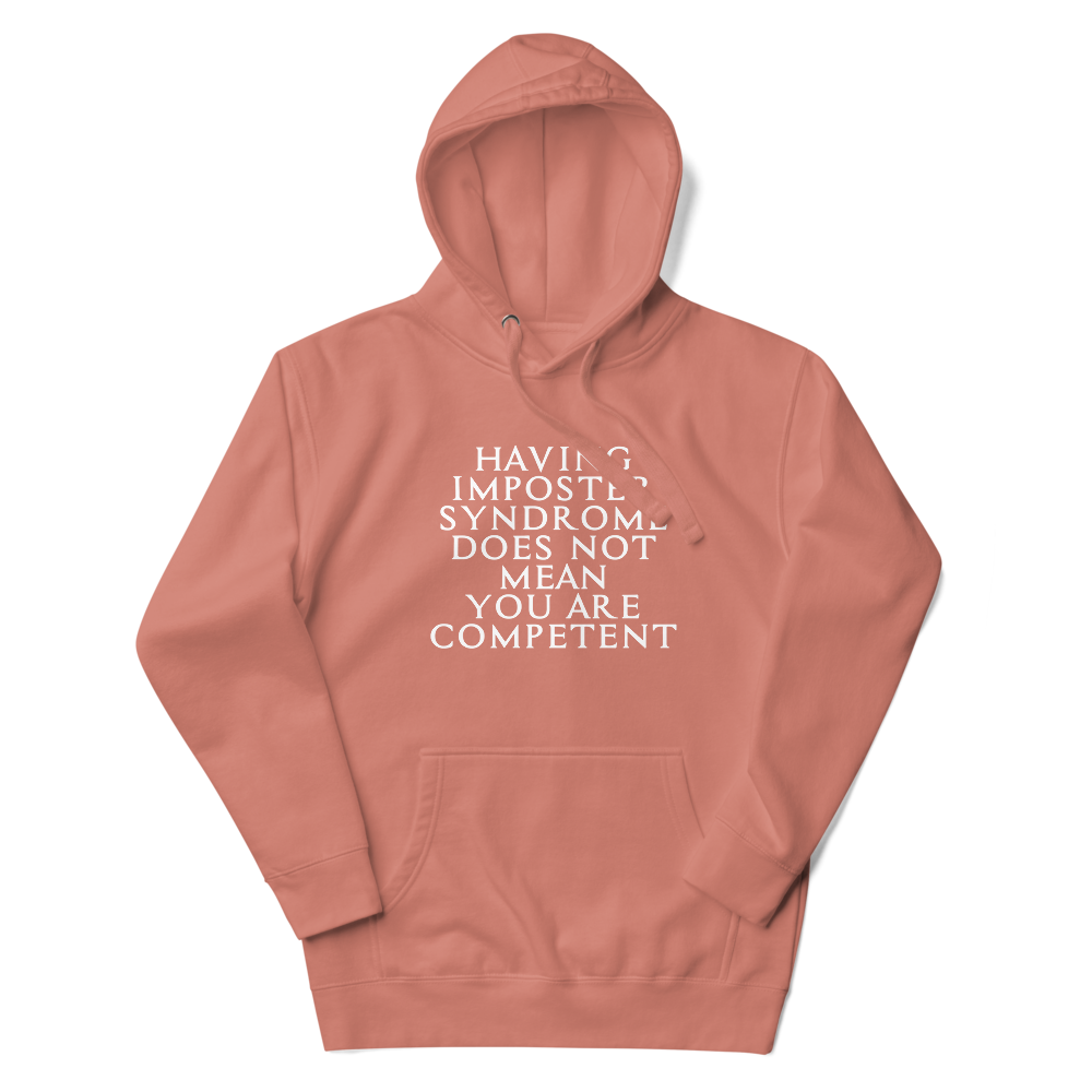 "Having Imposter Syndrome does not mean you are competent" printed on a dusty rose unisex hoodie laying on a flat surface with the hood up