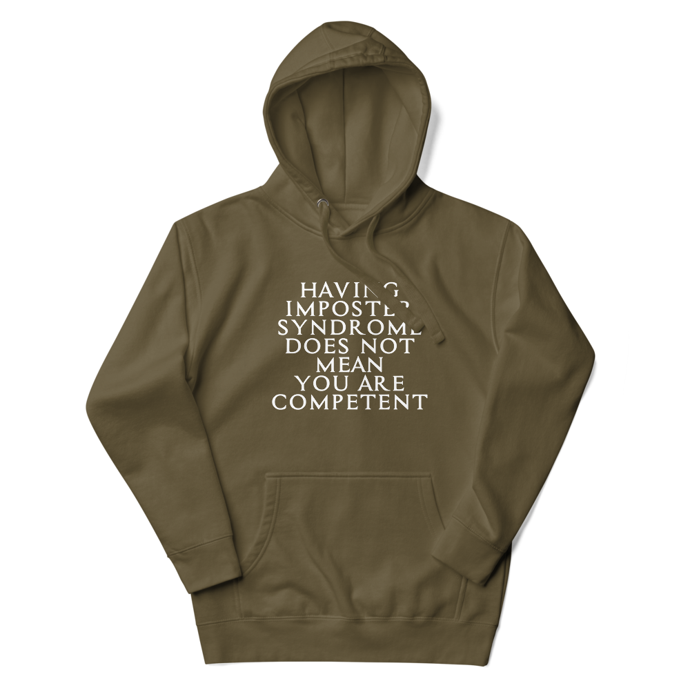 "Having Imposter Syndrome does not mean you are competent" printed on a military green unisex hoodie laying on a flat surface with the hood up