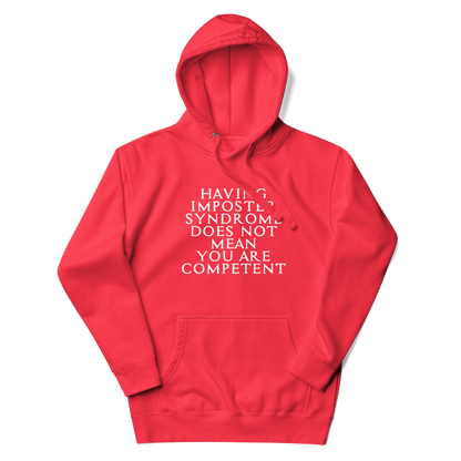 "Having Imposter Syndrome does not mean you are competent" printed on a team red unisex hoodie laying on a flat surface with the hood up