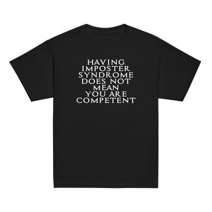 "Having Imposter Syndrome does not mean you are competent" printed on a black youth classic tee laying on a flat surface